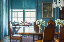 30 a stone blue dining room with vintage dinign furniture, a crystal chandelier and some vintage art is very chic
