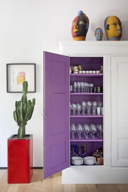 a white storage cabinet accented with very peri paint inside is a very cute and cool idea to rock