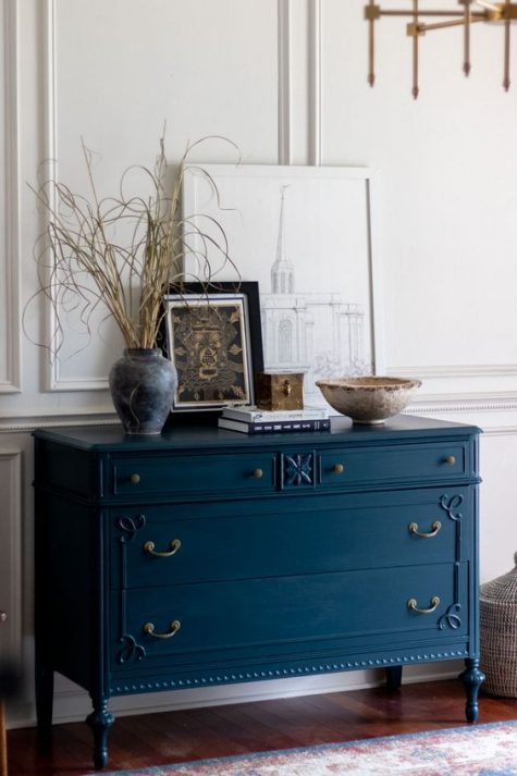 a beautiful vintage navy dresser with delicate matte handles and knobs is a very refined solution for your space
