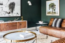 40 a dark green living room with brown leather sofas, a chic credenza, artwork and brass touches for more elegance