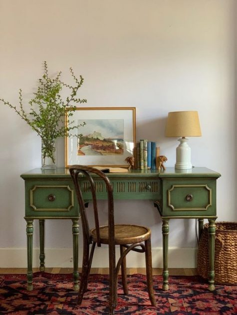 a vintage green desk with touches of gold and a matching vintage chair for a refined and chic work space