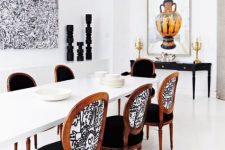 41 renovated vintage chairs and a black console table blend with a modern white dining table ina beautiful way