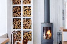 a Scandinavian space with a modern and cool wood burning stove plus an elegant open storage unit for firewood