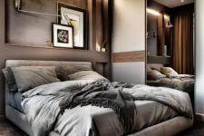 a beautiful taupe bedroom with lit up niches, a floating upholstered bed, grey bedding, lamps and a storage unit with a mirror sliding door