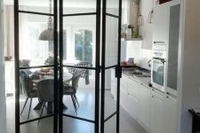 a black metal frame and glass folding door is a lovely idea to separate your spaces in a subtle way and let natural light go in