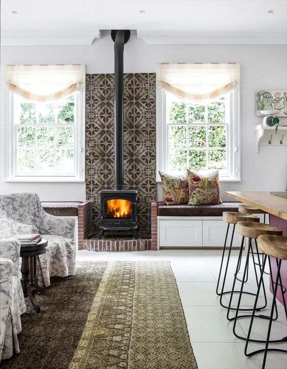 a bright space with printed tiles and brick around the hearth, floral printed furniture and printed pillows and a rug