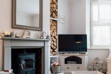 a chic and airy living room with a wood burning stove placed in the fireplace, a mantel with decor, firewood in the niches and vintage furniture
