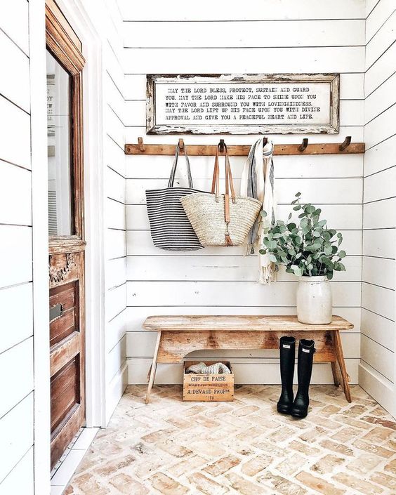 a cozy farmhouse entryway done with white shiplap plus a brick floor is a very chic and budget friendly idea