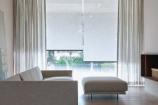 a cute neutral living room with blinds and curtains