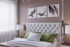 a modern bedroom with a taupe accent wall, a white leather bed, floating nightstands, a taupe blanket and a chic chandelier