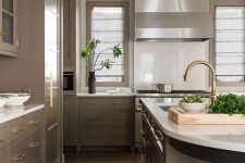 a modern taupe kitchen with sleek cabinets and gold handles, a stainless steel hood, white stone countertops, wooden stools