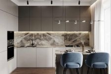 a refined contemporary kitchen with matte taupe and white cabinets, a white and grey marble backsplash and countertops and black fixtures