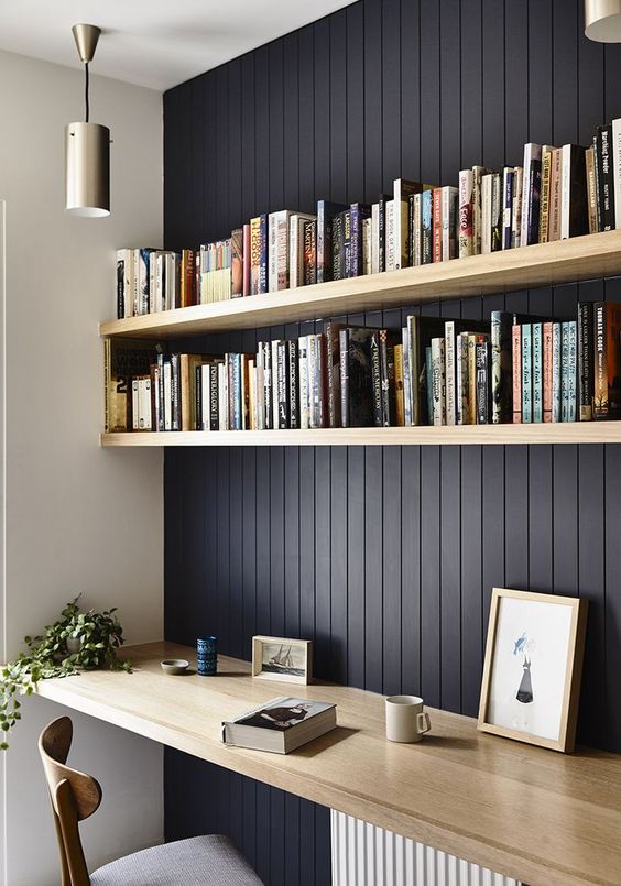 a stylish contemporary home office with black vertical shiplap on the statement wall and light stained wooden furiture