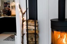 a stylish modern hearth plus a matching black wall-mounted stand for firewood are amazing to infuse your spaces with warmth