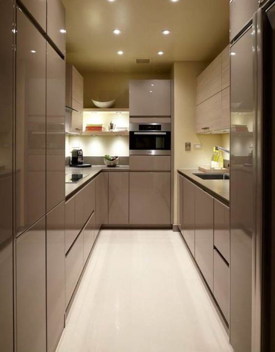 a super sleek and glossy taupe kitchen with no handles and built-in lights, with a pastel yellow sleek backsplash and countertops