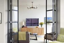 black frame and glass folding doors delicately separate the spaces and accent the decor a lot while letting light in and out
