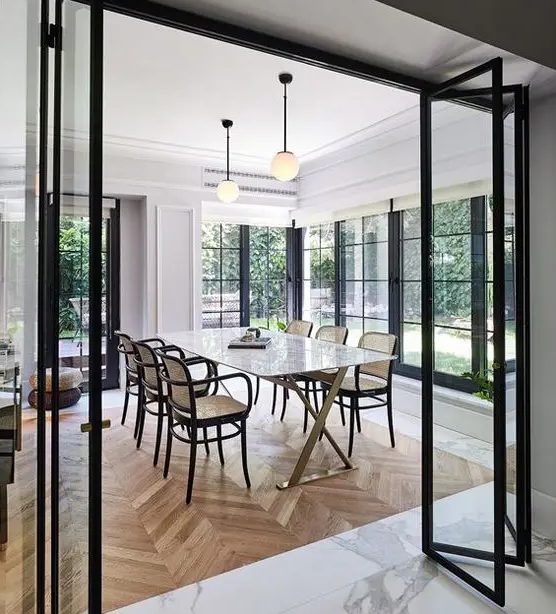 black frame and glass folding doors look very lightweight and separate the spaces subtly letting people enjoy light and views through these doors