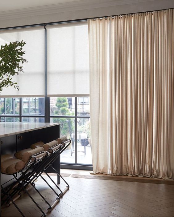 blinds paired with elegant and a bit shiny neutral curtains give a chic and beautiful touch to the space