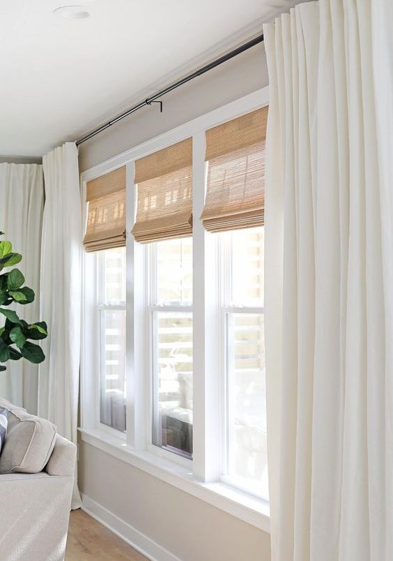 budget-friendly cordless woven shades and linen cotton curtains, paired with black curtain rods