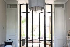 double-height black frame bi-fold doors let more light in the space and almost create one single space of two rooms
