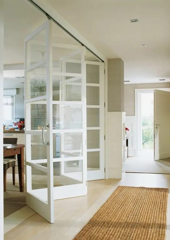 glass and white wood folding doors look very lightweight and ethereal, they subtly divide the spaces and look neutral and calming