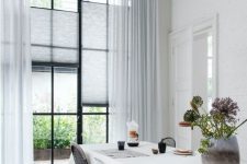 semi-sheer off-white blinds paired with matching flowy curtains help to highlight the contemporary style of the space