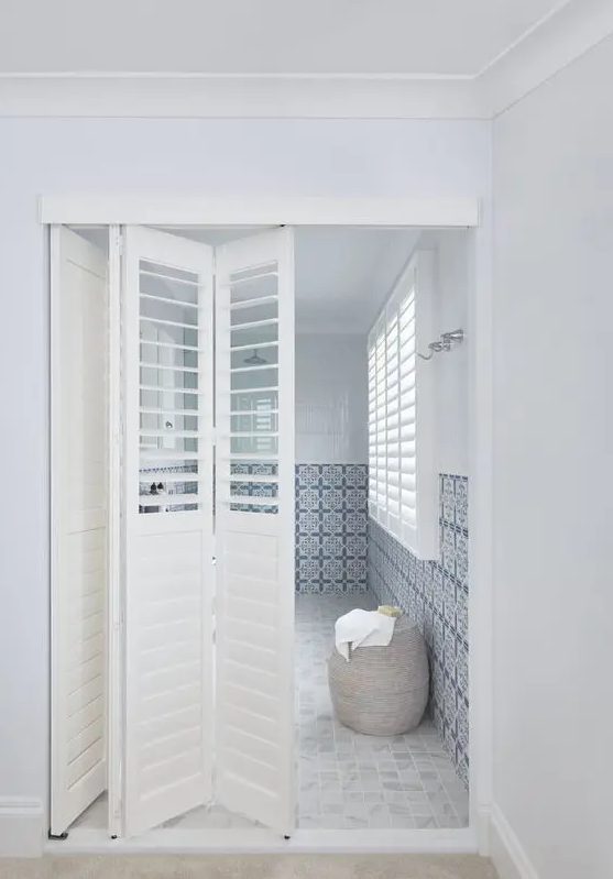 white shutter folding doors leading to the en-suite bathroom are enough to separate it from the bedroom and don't divide the space too much