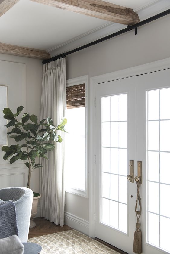 woven shades and neutral curtains make the space look cozy and elegant adding a timeless feel to the space