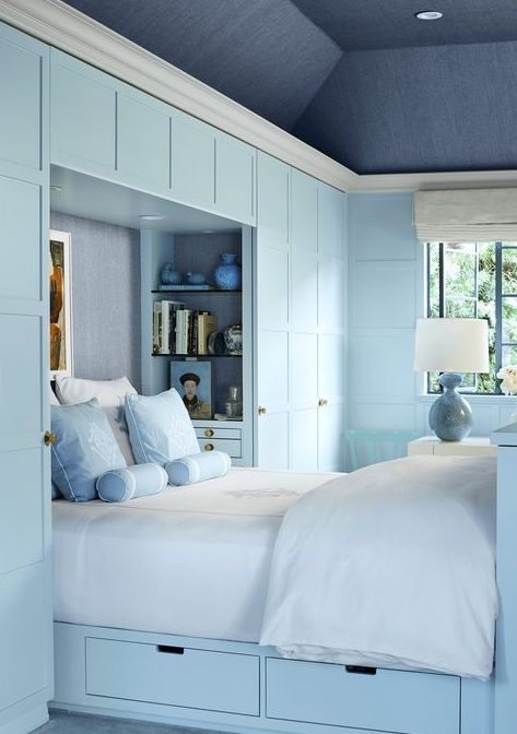 a built-in powder blue bed with a couple of visible drawers is a cool storage idea for a small bedroom in any style