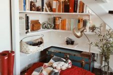 04 a fab reading nook under the stairs with corner shelves, lights, a vintage chest for storage, large pillows and blankets