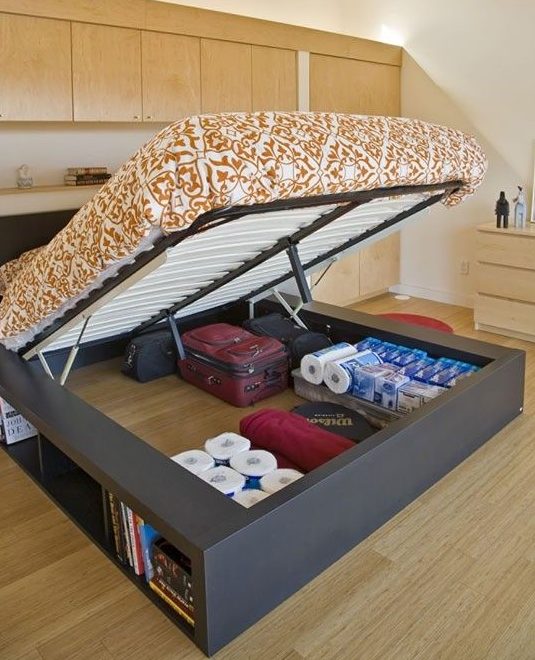 a large storage bed with a lot of things stored inside and open storage compartments is very cool
