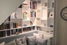 12 a stylish reading nook with open bookshelves and a daybed with lots of pillows is a very cool and smart idea to use this space