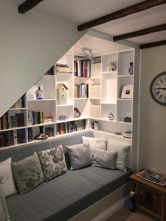 a stylish reading nook with open bookshelves and a daybed with lots of pillows is a very cool and smart idea to use this space