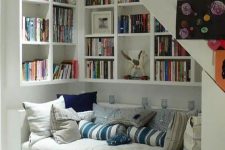 14 a welcoming white reading nook with built-in bookshelves and a couch with storage is a very cozy space to curl here