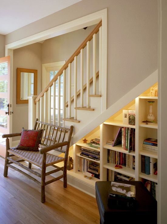 a bookcase built in under the stairs, with additional lights to make choosing a book easier
