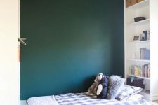 a boy’s bedroom with a green accent wall