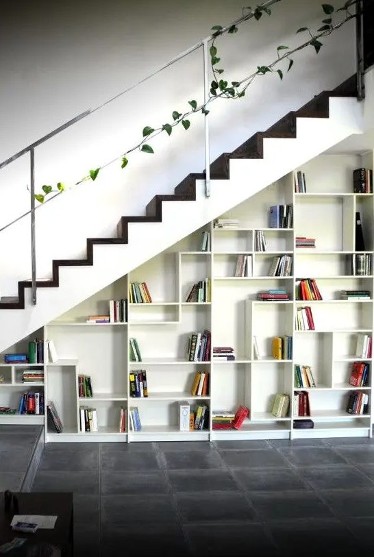 a built-in bookcase with geometrically placed shelves and books becomes a cool decor feature