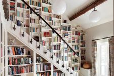 21 a fantastic bookcase that takes a whole wall over the stairs and all the space under them is a gorgeous idea for book lovers