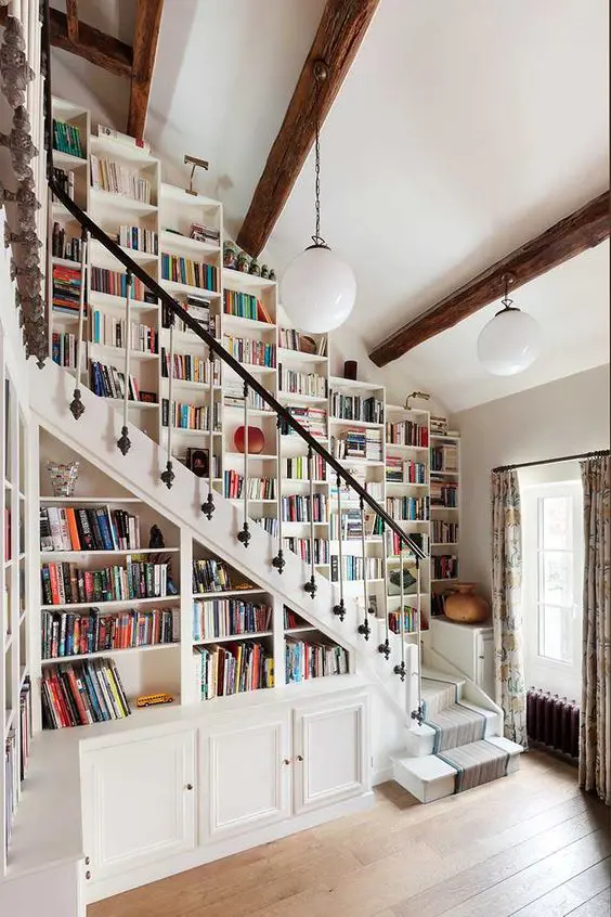 a fantastic bookcase that takes a whole wall over the stairs and all the space under them is a gorgeous idea for book lovers