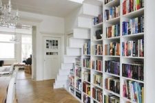 22 a large bookcase built under the stairs is all you need to save the space and acomodate them all