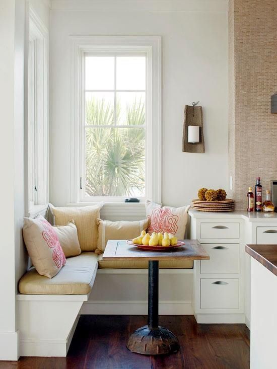 a tiny akward nook in the kitchen turned into a breakfast one, with a built-in corner bench with pillows and a small table