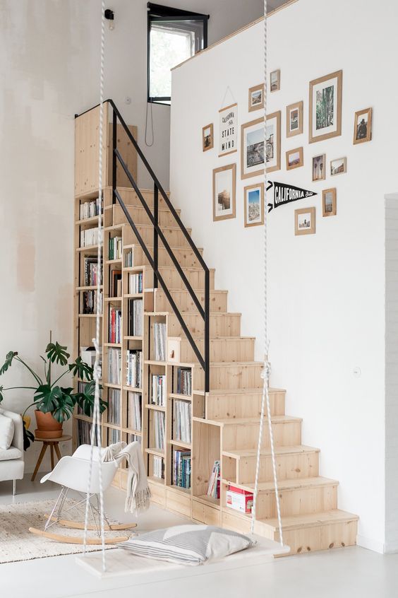 a Scandinavian space with a light-stained staircase, with shelves built-into it for a practical use is all cool