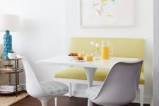 27 a modern and bright breakfast nook with a mustard loveseat, a white table and catchy white chairs with upholstery