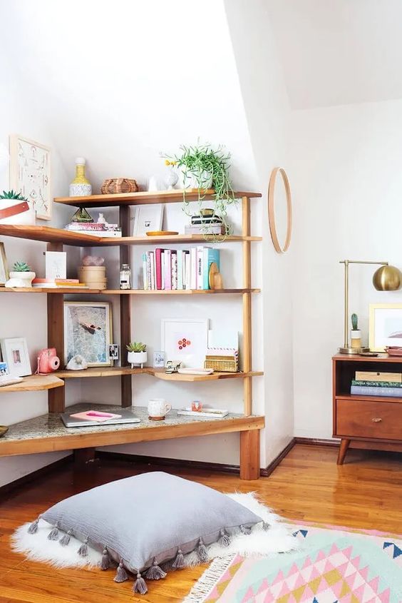 an awkward nook finished off with a large storage unit with lots of shelves, potted plants, books and various types of decor