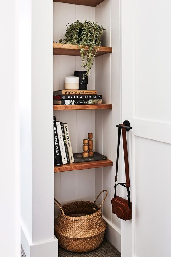 a tiny nook done with stained shelves, with a basket, books, candles and a potted plant is a lovely idea for any room
