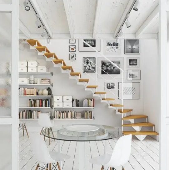 an airy whitewashed Scandinavian space with floating bookshelves under the stairs - this space can also act as a home office