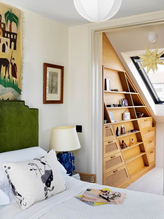 an attic nook taken by a large and elegant stained wood storage unit with lots of shelves and drawers is a smart idea