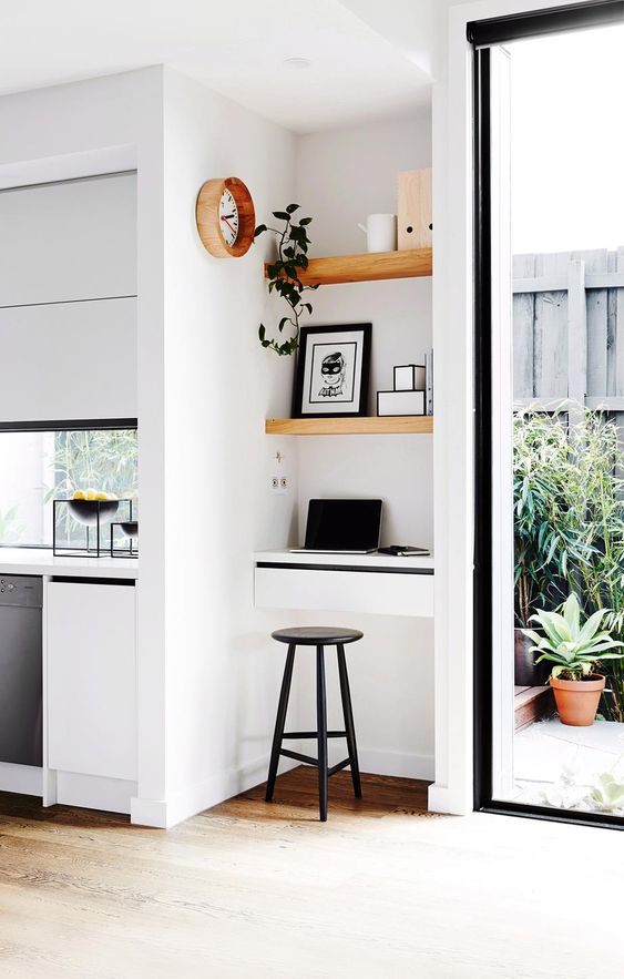 a tiny nook take by light-stained built-in shelves and even a tiny built-in desk for working here