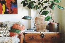 36 a cozy and cool nook takedn by a large vintage sideboard, with a potted plant, a cage and a lamp is a lovely idea