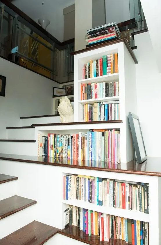 bookshelves built in right into the staircase in a smart and a creative way  to use every inch of space